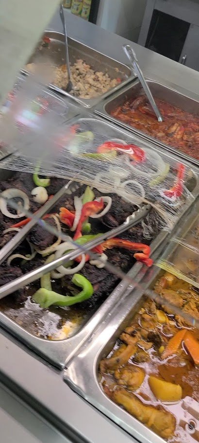 Caribbean restaurant counter with buffet-style dishes.