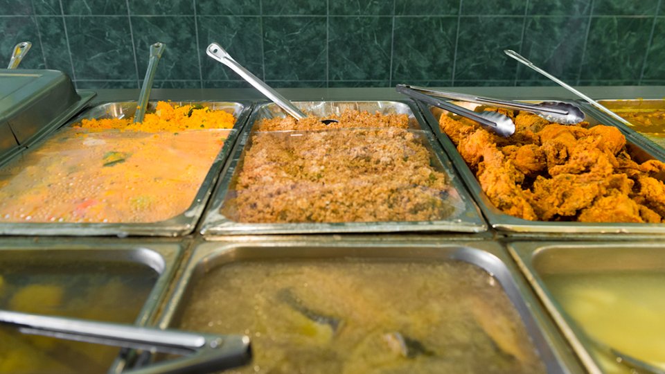 Restaurant menu with oxtail, curry goat, and drinks.